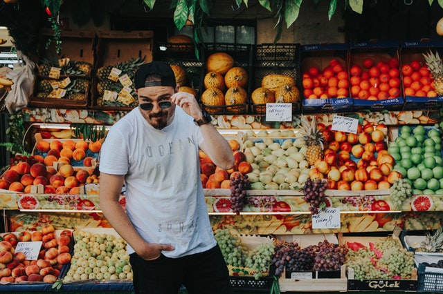 man-standing-beside-assorted-fruits-2042085